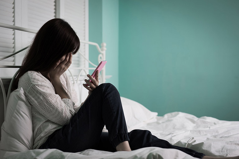 80029713   Woman Feel Depression And Look Phone Sit On The Bed